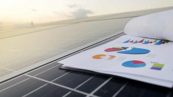 Photovoltaik Module auf dem ein Blatt mit Diagramme liegt